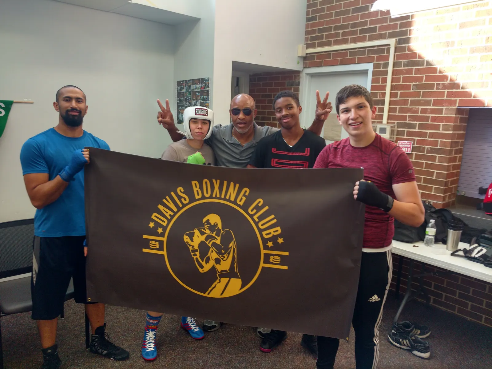 Coaches and boxers holding the Davis Boxing Club banner