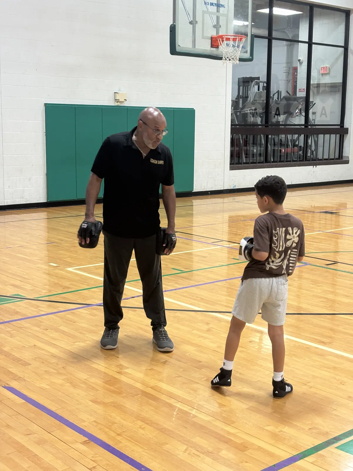 A coach working footwork with a young boxer