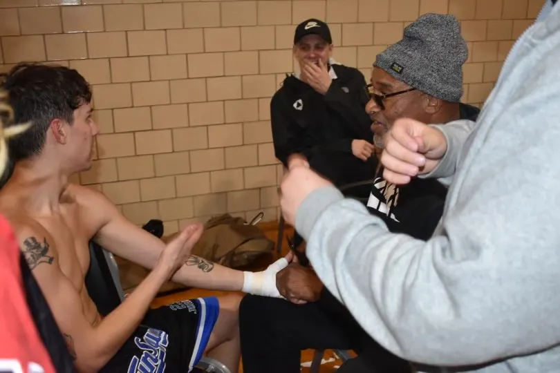 A coach checking a boxer's hand wraps